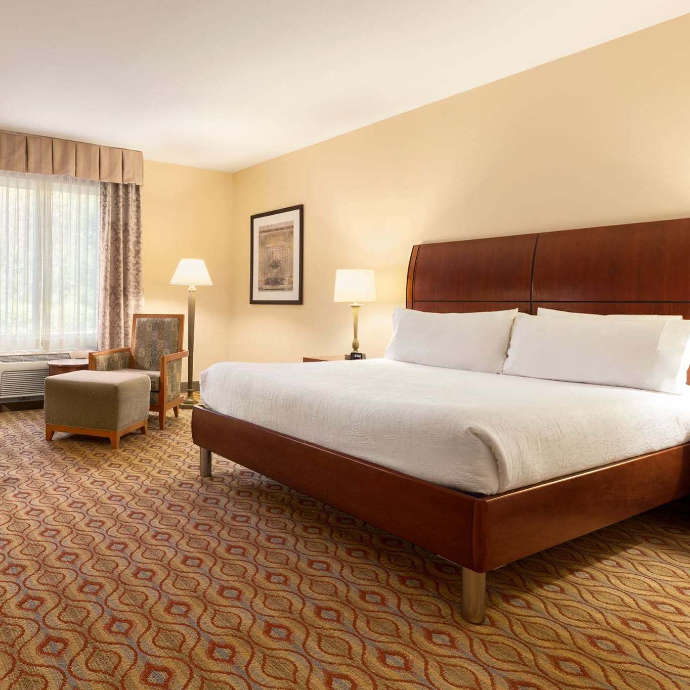 Guest room with a king sized bed and chair