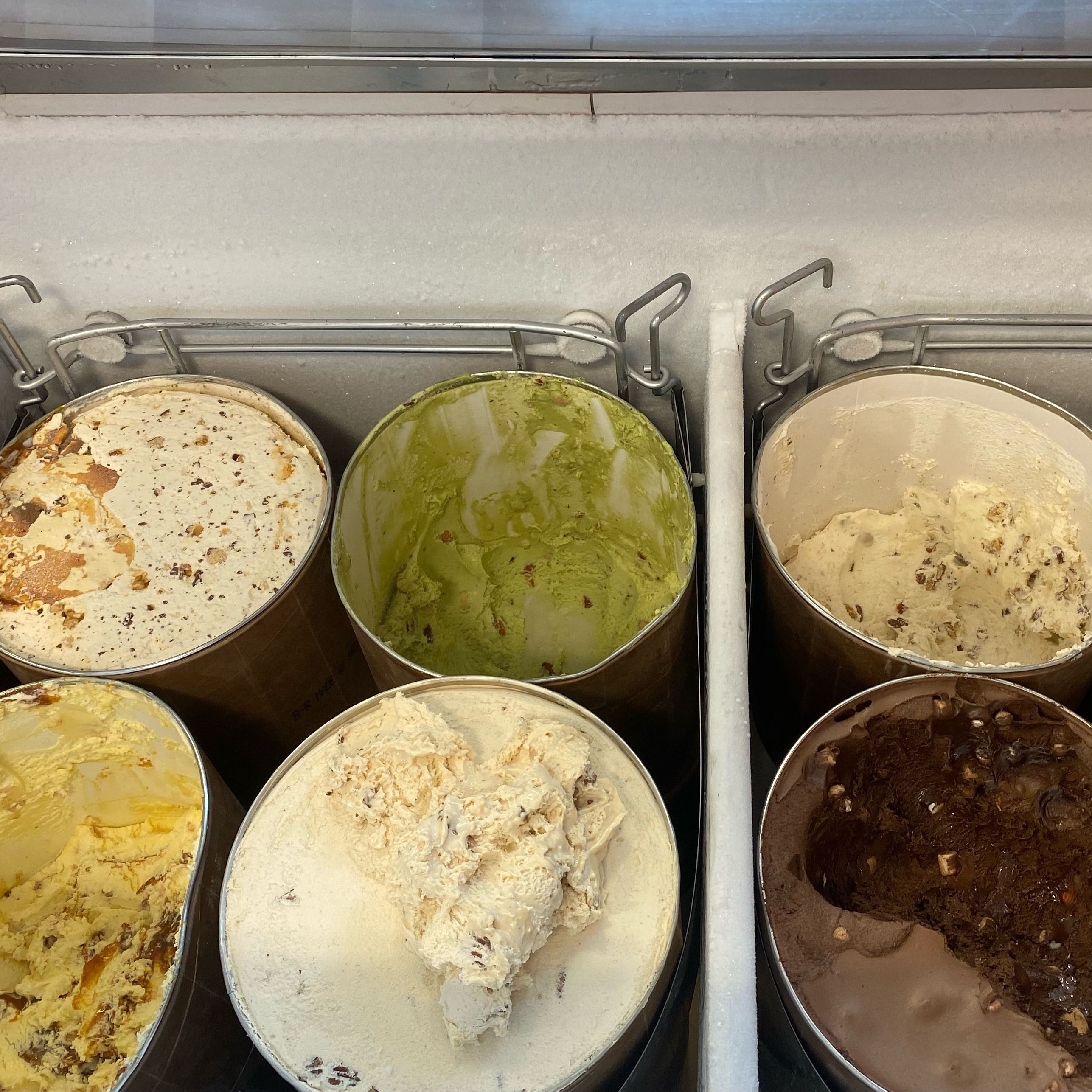 A variety of ice cream flavor tubs in a freezer chest