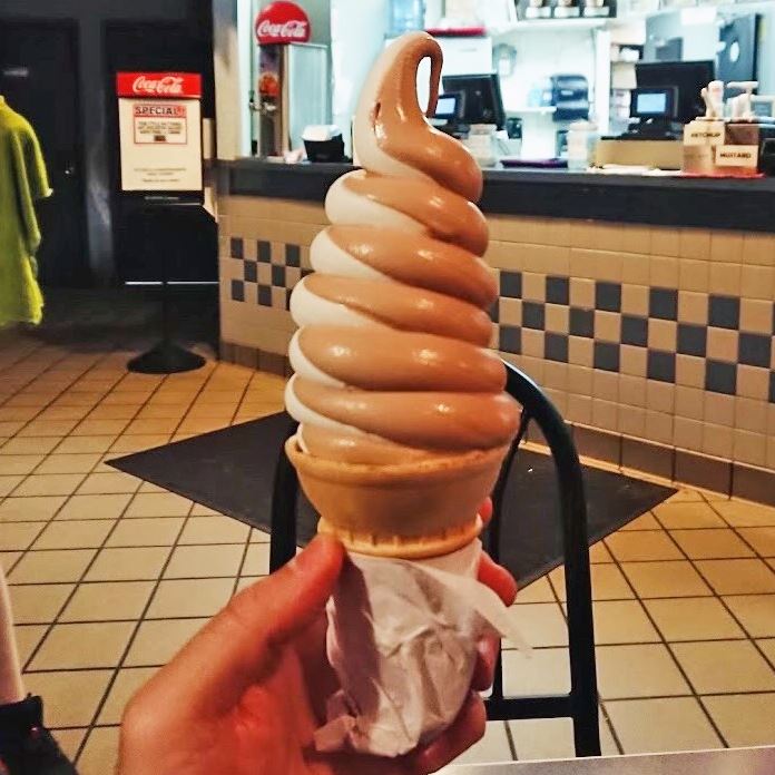 Chocolate and vanilla swirl soft serve ice cream on a cone