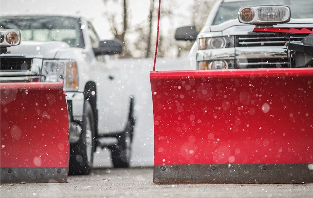 White trucks with red snow plows